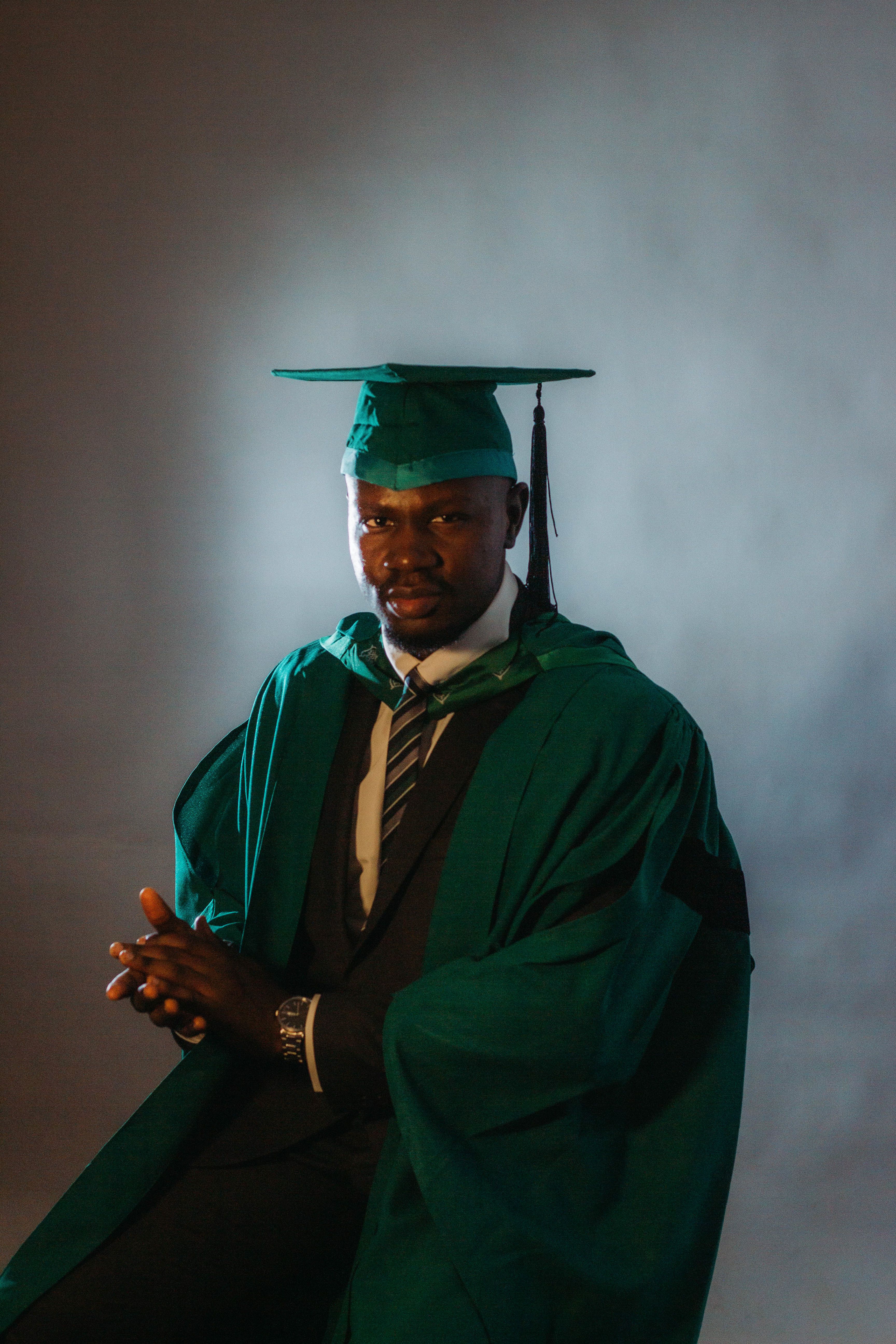 Graduate Portrait in Green Academic Robe · Free Stock Photo