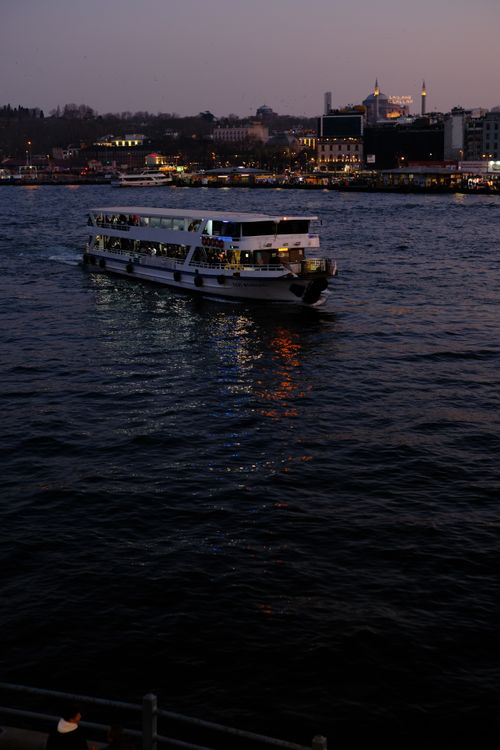 Free A ferry glides across the Bosphorus at dusk, with Istanbul's skyline in the background. Stock Photo