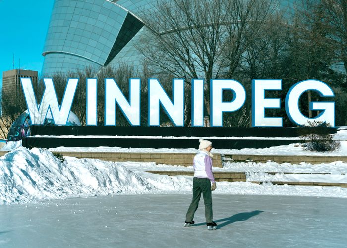Outdoor ice skater at the Winnipeg sign during a sunny winter day