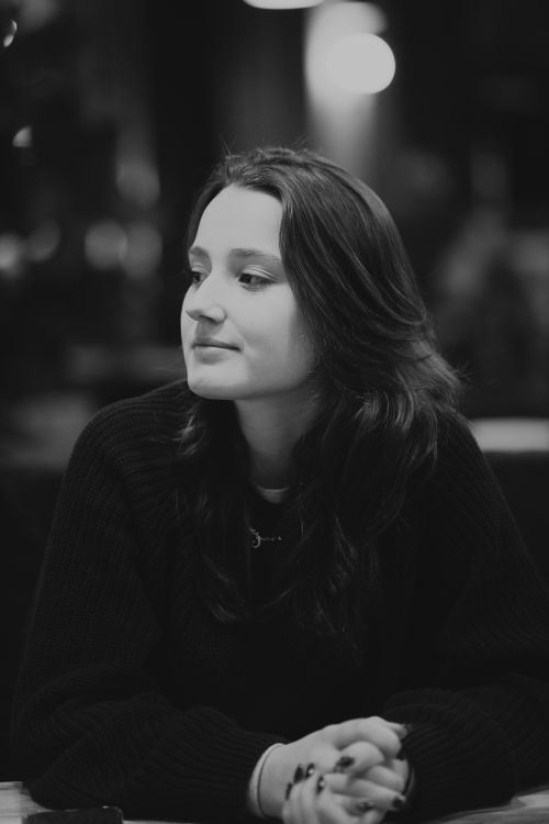 Free Black and white portrait of a thoughtful woman sitting indoors, exuding a serene mood. Stock Photo