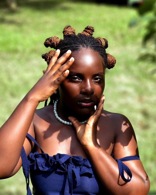 Free Elegant woman with braided hair posing outdoors in sunlight, casting playful shadows. Stock Photo