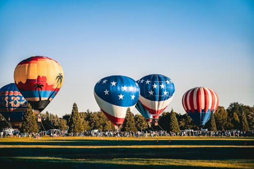 Anchored Hot Air Balloons at Field Full Of People