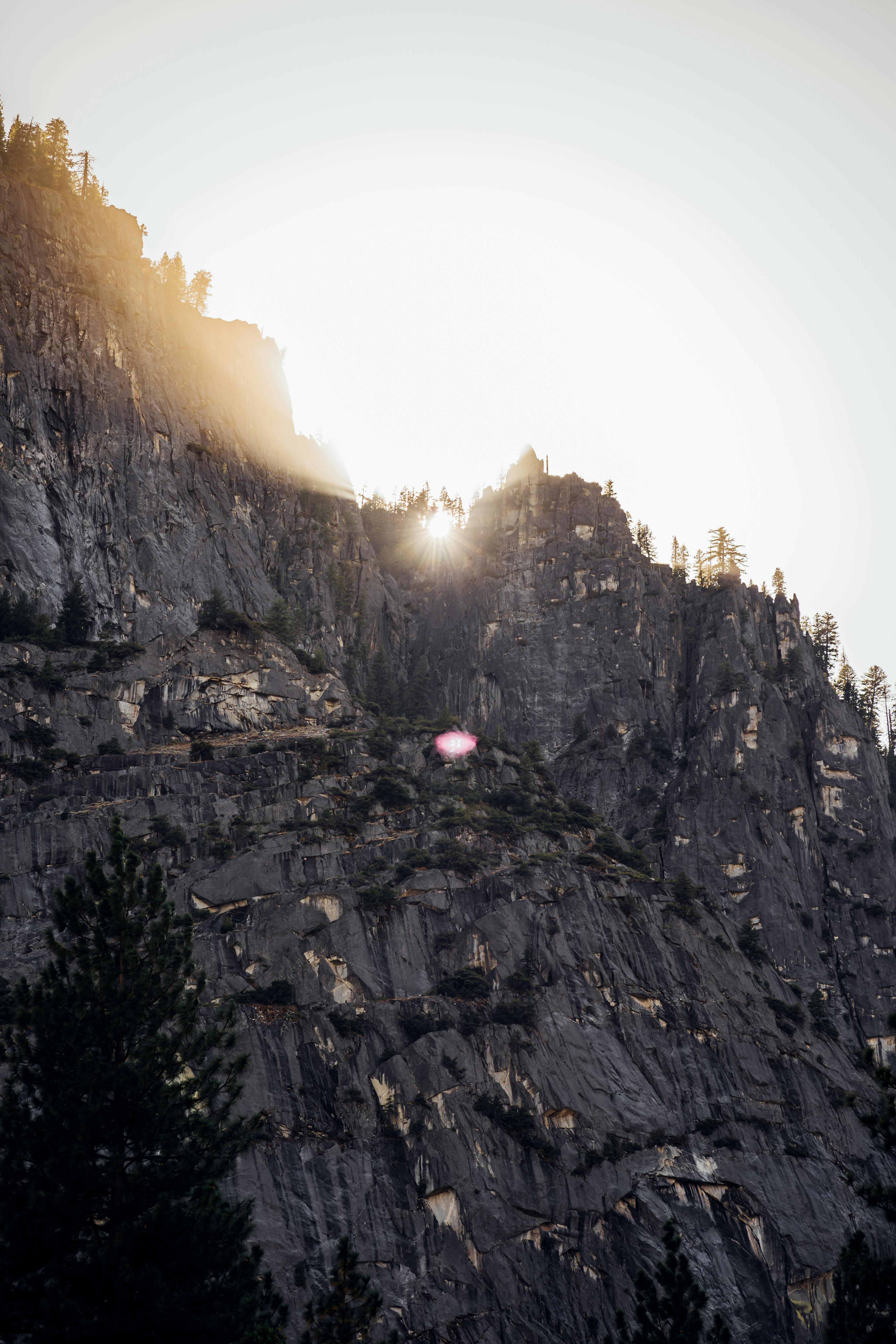 日出将温暖的光线投射在崎岖的山岩上，营造出壮丽的自然景象