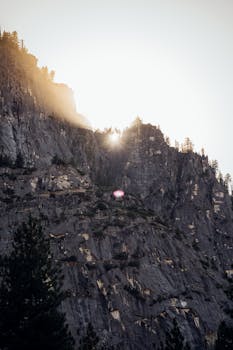 日出将温暖的光线投射在崎岖的山岩上，营造出壮丽的自然景象