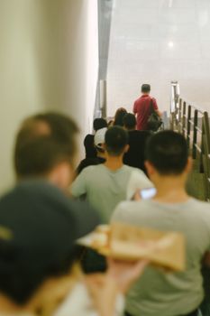 一群模糊的成年人在室内走下楼梯，捕捉着运动和城市生活的瞬间
