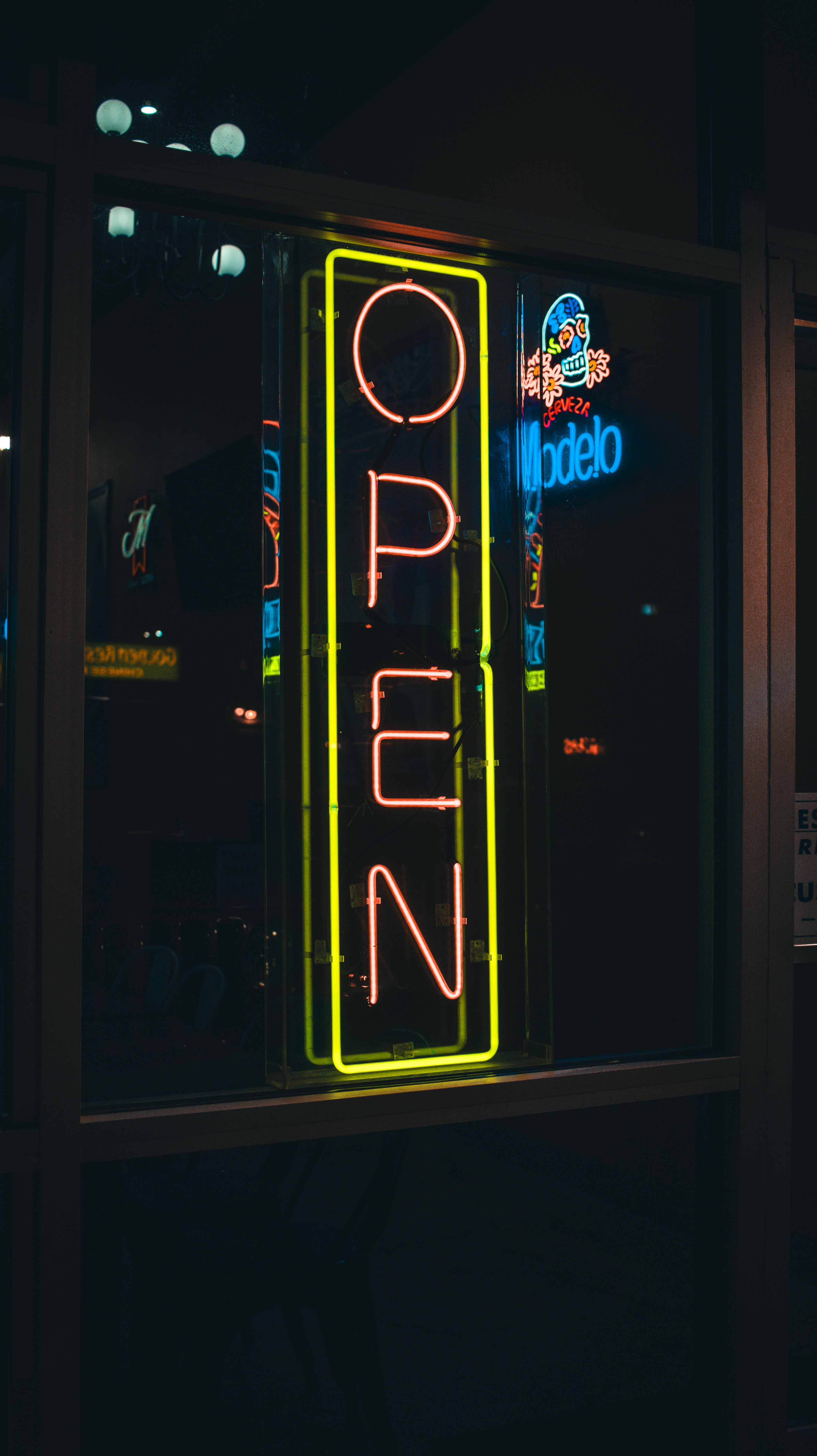 Neon 'Open' sign glowing brightly in an urban street at night, Fresno, California.