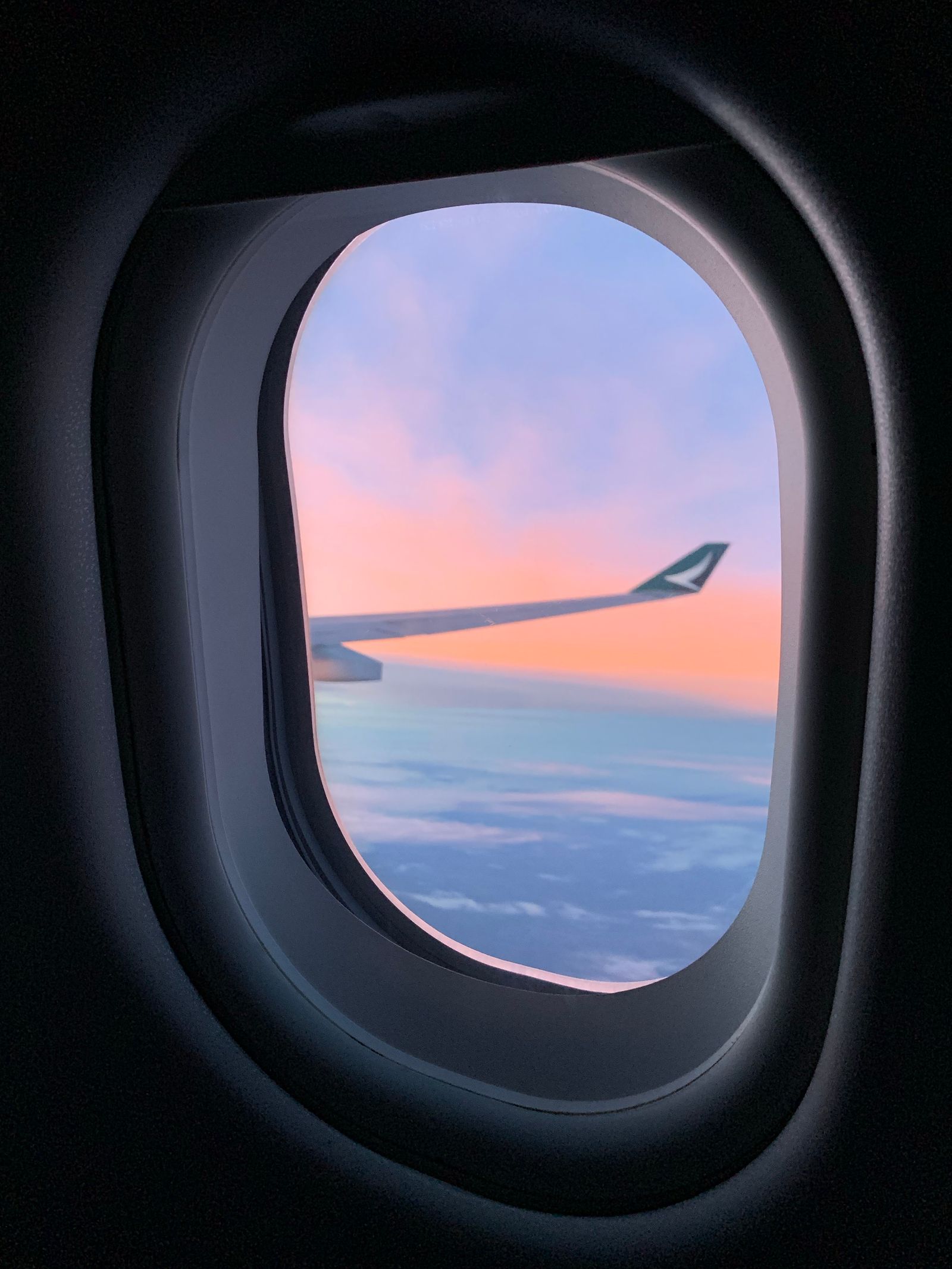 A private jet wing against a sunset sky