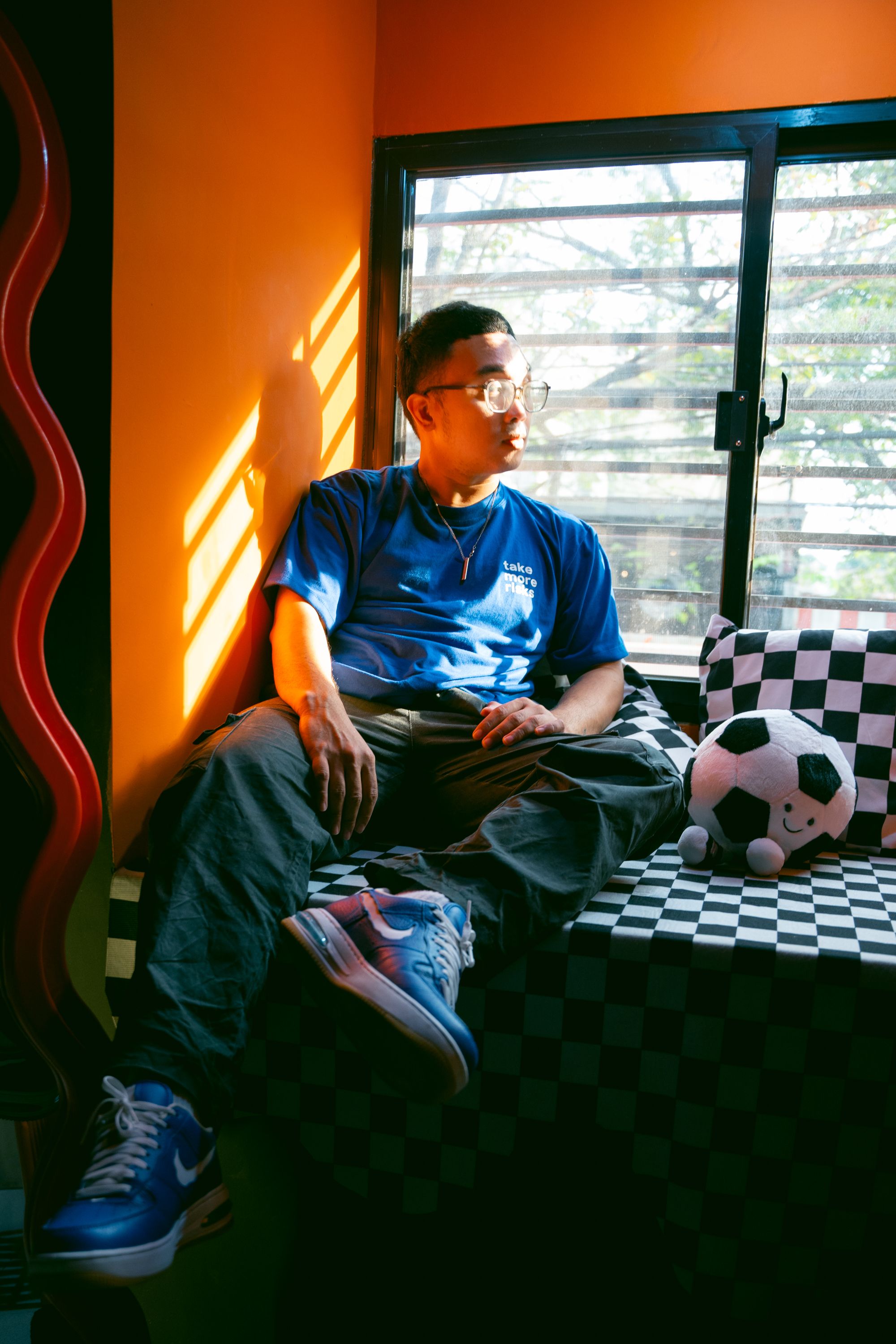 Casual scene of a man sitting by a bright window with playful decor.