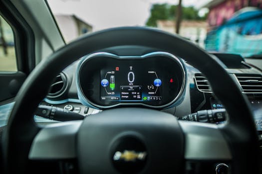 Close-up of a car's dashboard featuring a digital display and steering wheel.