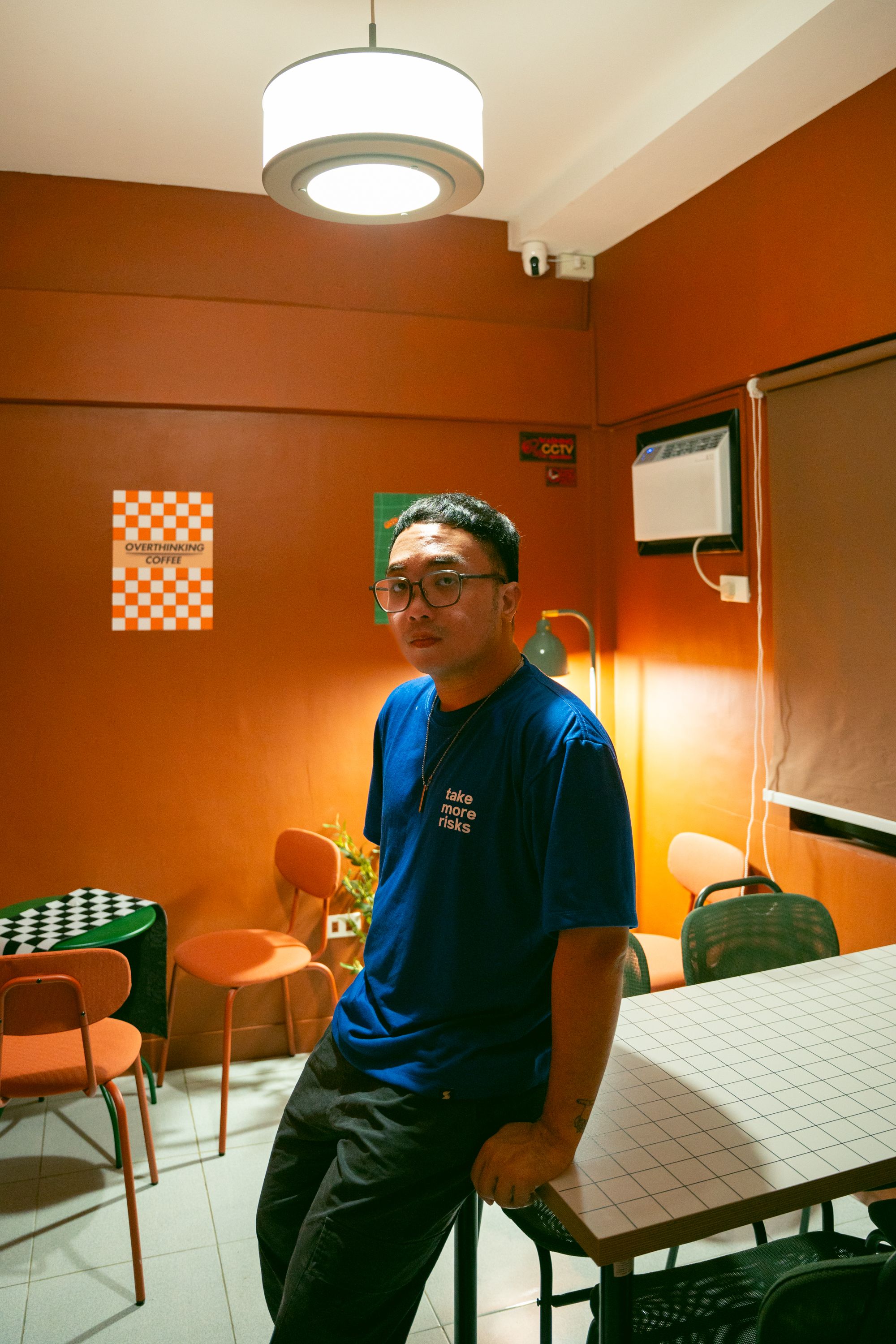 A man in a vibrant cafe with warm decor and modern furniture.