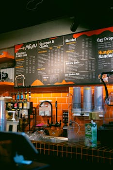 Cozy coffee shop interior featuring a detailed menu and beverage preparation area.