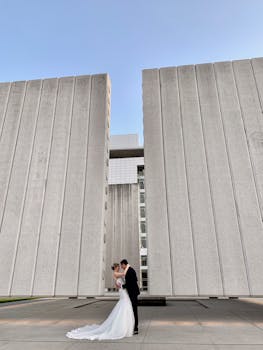 在时尚的建筑结构前，新娘和新郎相拥，捕捉永恒的爱