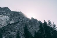 崎岖的山峦与树木在日出中形成戏剧性的剪影