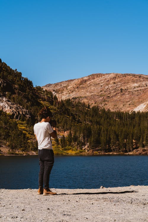 Free Person Talking A Photo Of The Lake Surrounded By idyllic scenery  Stock Photo