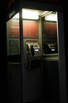 Dimly lit Telstra phone booth at night captures vintage urban vibe.