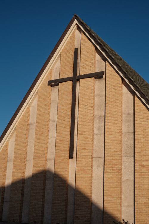 Free Modern church facade featuring prominent cross and geometric design Stock Photo