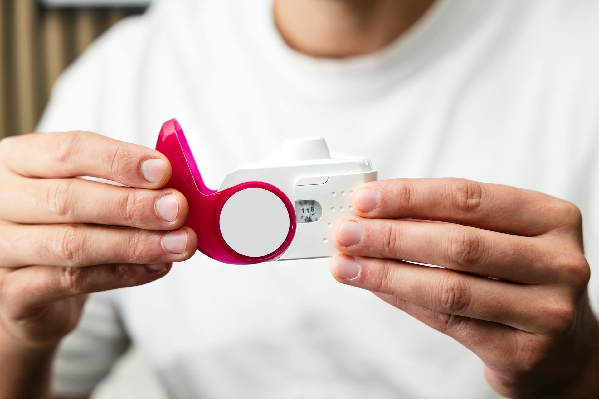 Close-up of hands holding a peak flow meter for respiratory health monitoring.