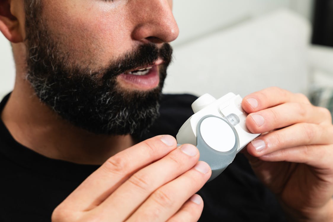 Man Using Inhaler for Breathing Assistance · Free Stock Photo