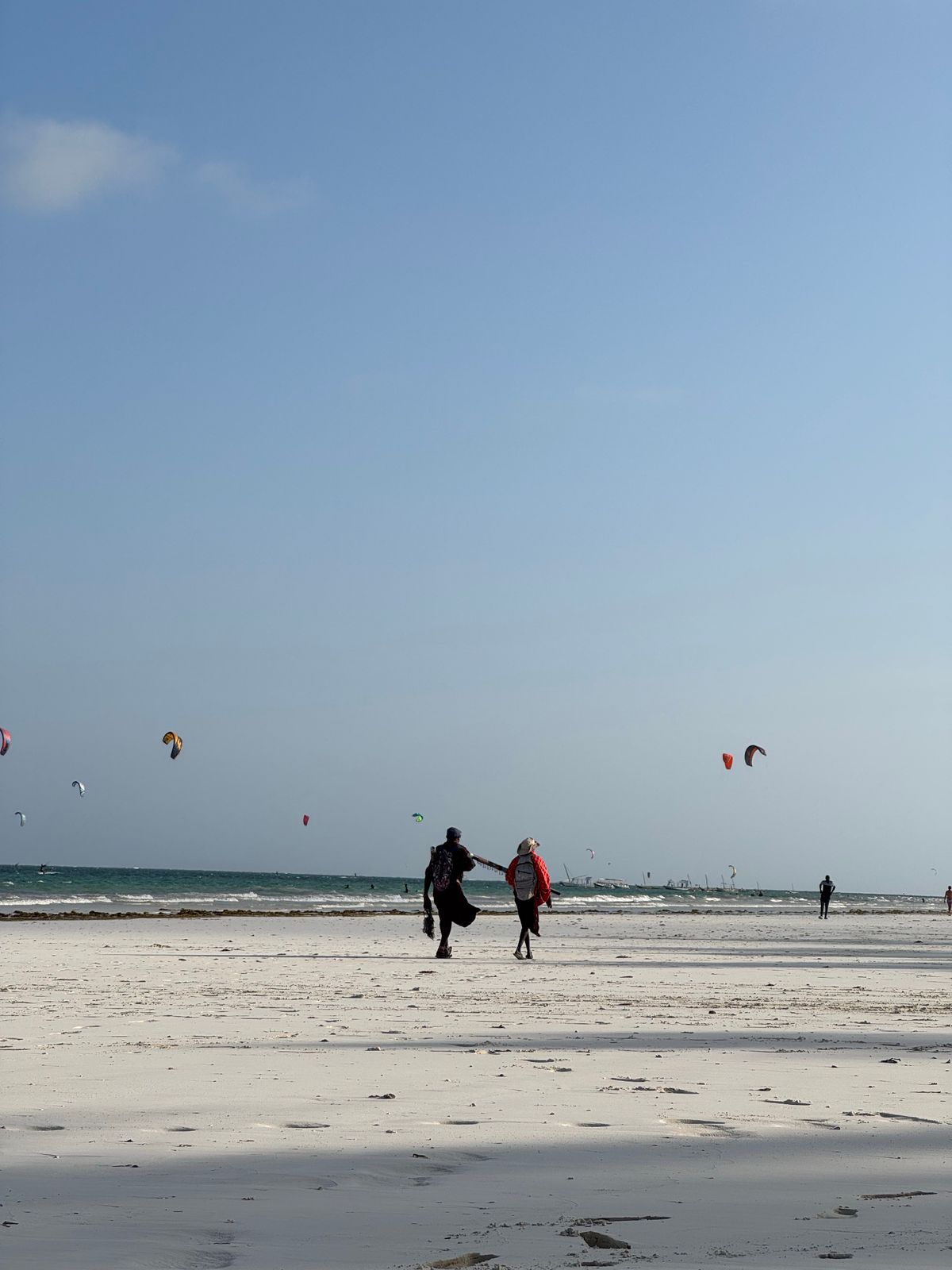 Unde te cazezi în Zanzibar - Paje - kitesurferi mergând pe plajă cu paravanele lor