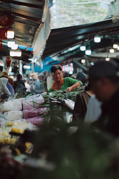 A vibrant Asian market with vendors and shoppers immersed in lively trade activities.