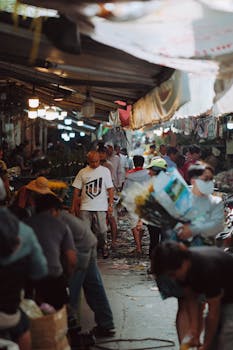 Bustling market scene with diverse group of shoppers in an Asian marketplace.