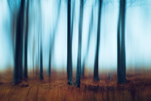 Artistic blur of a forest creates a dreamy abstract effect with vertical lines and vibrant colors.
