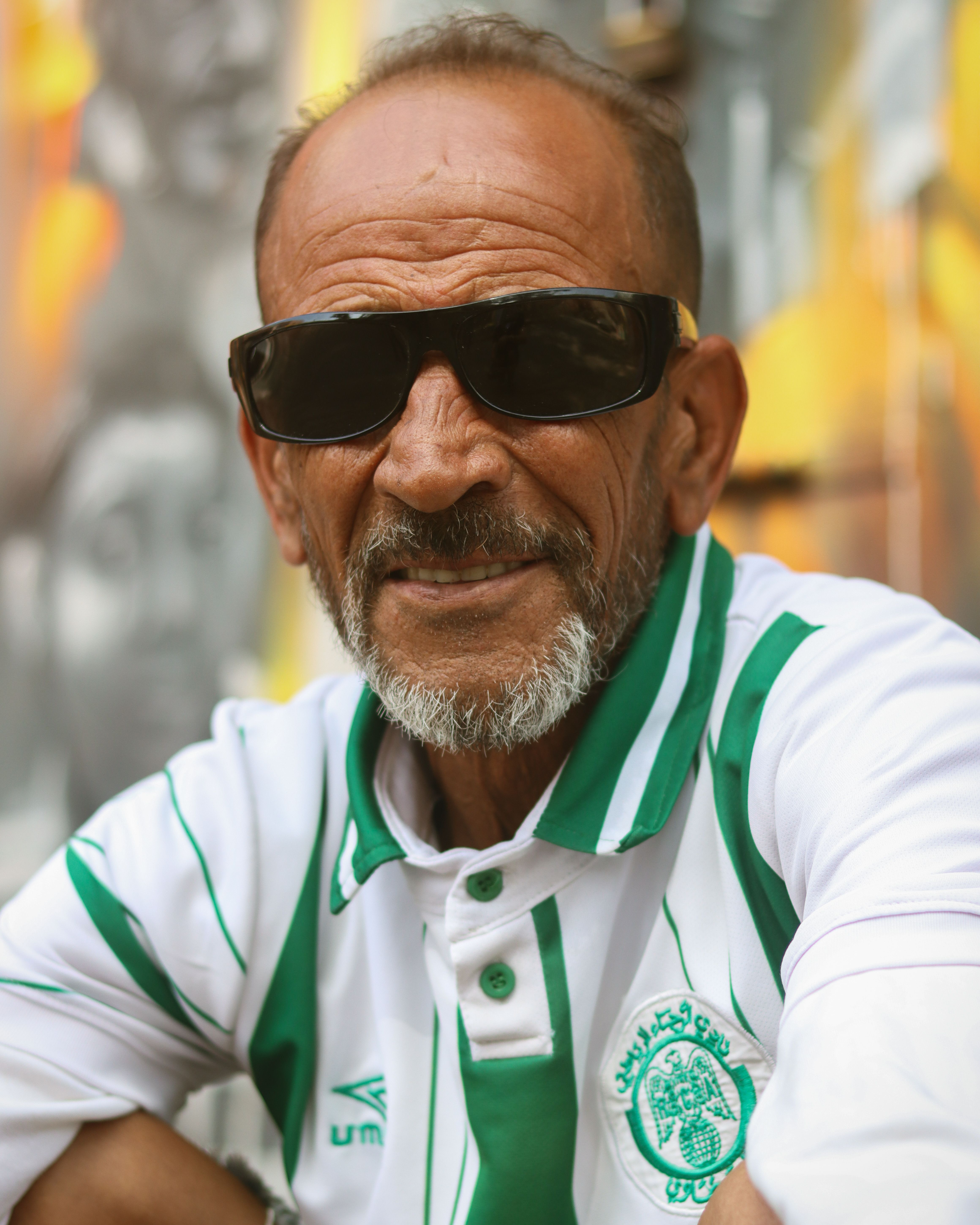 Senior man wearing sunglasses and a patterned shirt in Casablanca, Morocco, an urban setting.