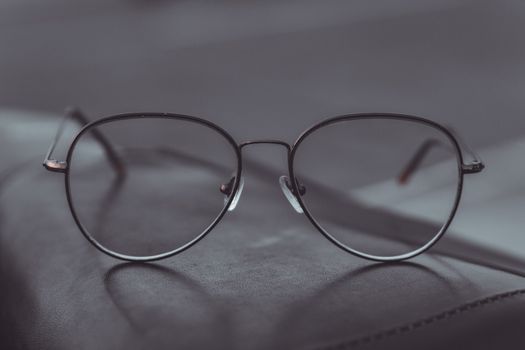 Stylish aviator glasses resting on a leather surface, showcasing sleek design.