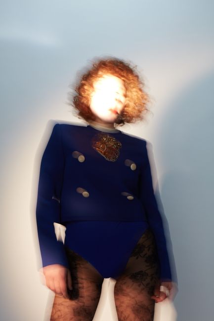 Creative fashion portrait featuring a woman with motion blur effect in stylish attire.
