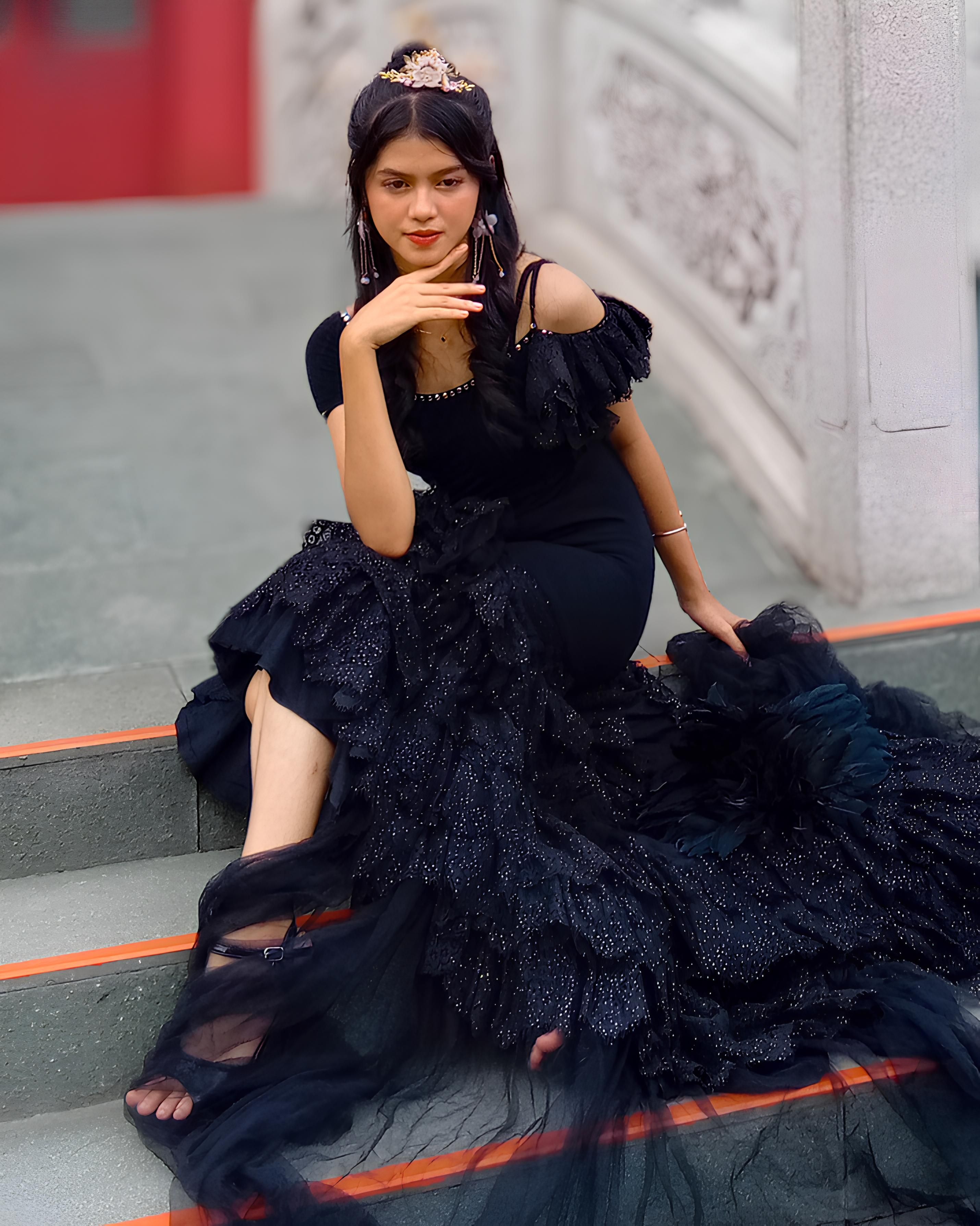 Elegant Woman in Black Ruffled Dress on Steps  Free Stock Photo