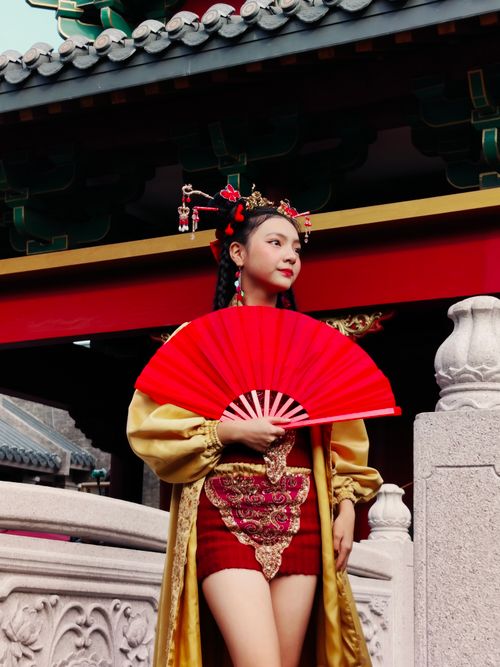 Free Woman in traditional Chinese attire holding a red fan outdoors in North Jakarta. Stock Photo