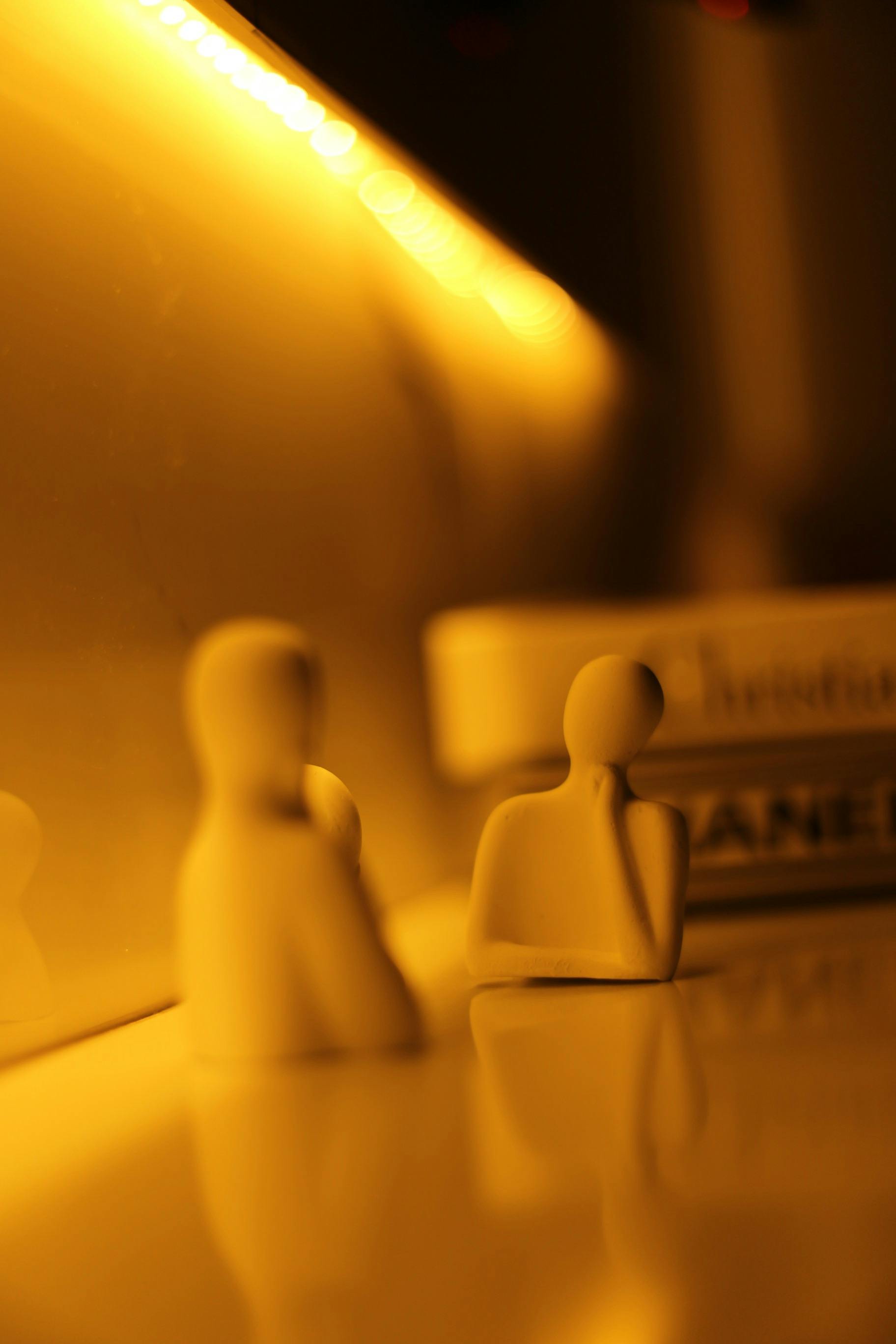 Gratis Silhouette di figure astratte con luci calde, che creano un'atmosfera suggestiva. Foto a disposizione