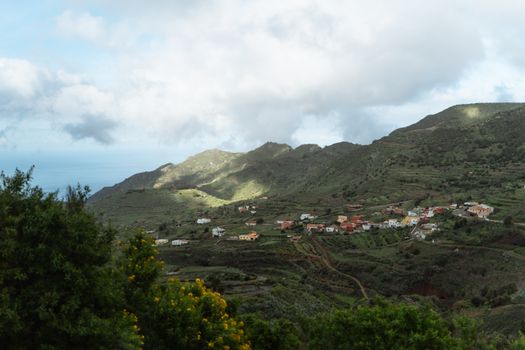 Picturesque green valley with traditional houses and terraced fields on the Canary Islands.