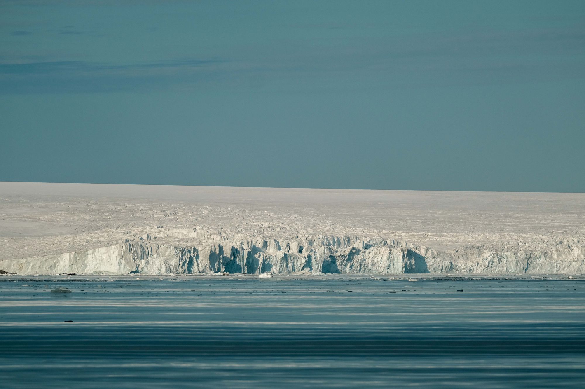 Stunning view of an Antarctic ice shelf with a serene frozen landscape and clear blue sky.