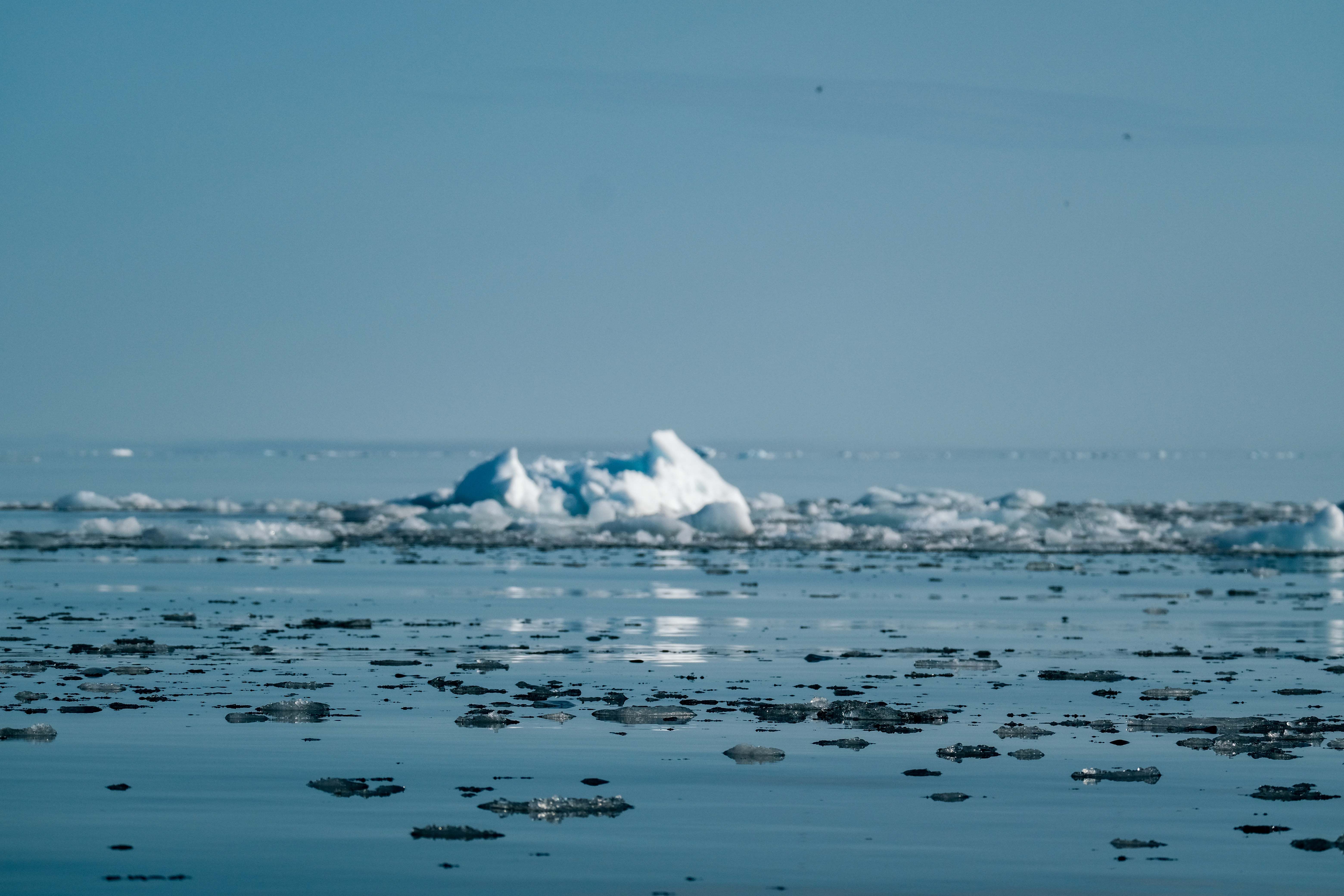 Melting sea ice floe breaking apart in dark Arctic waters