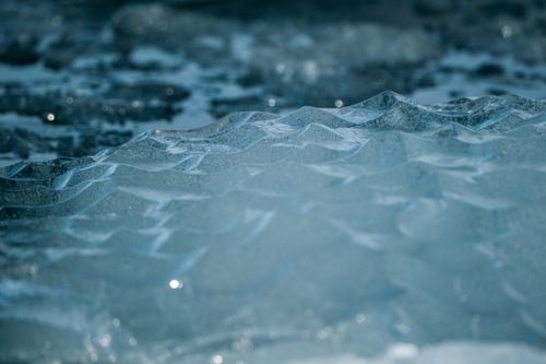 Free Detailed close-up of icy surface texture with shimmering reflective light, capturing winter chill. Stock Photo