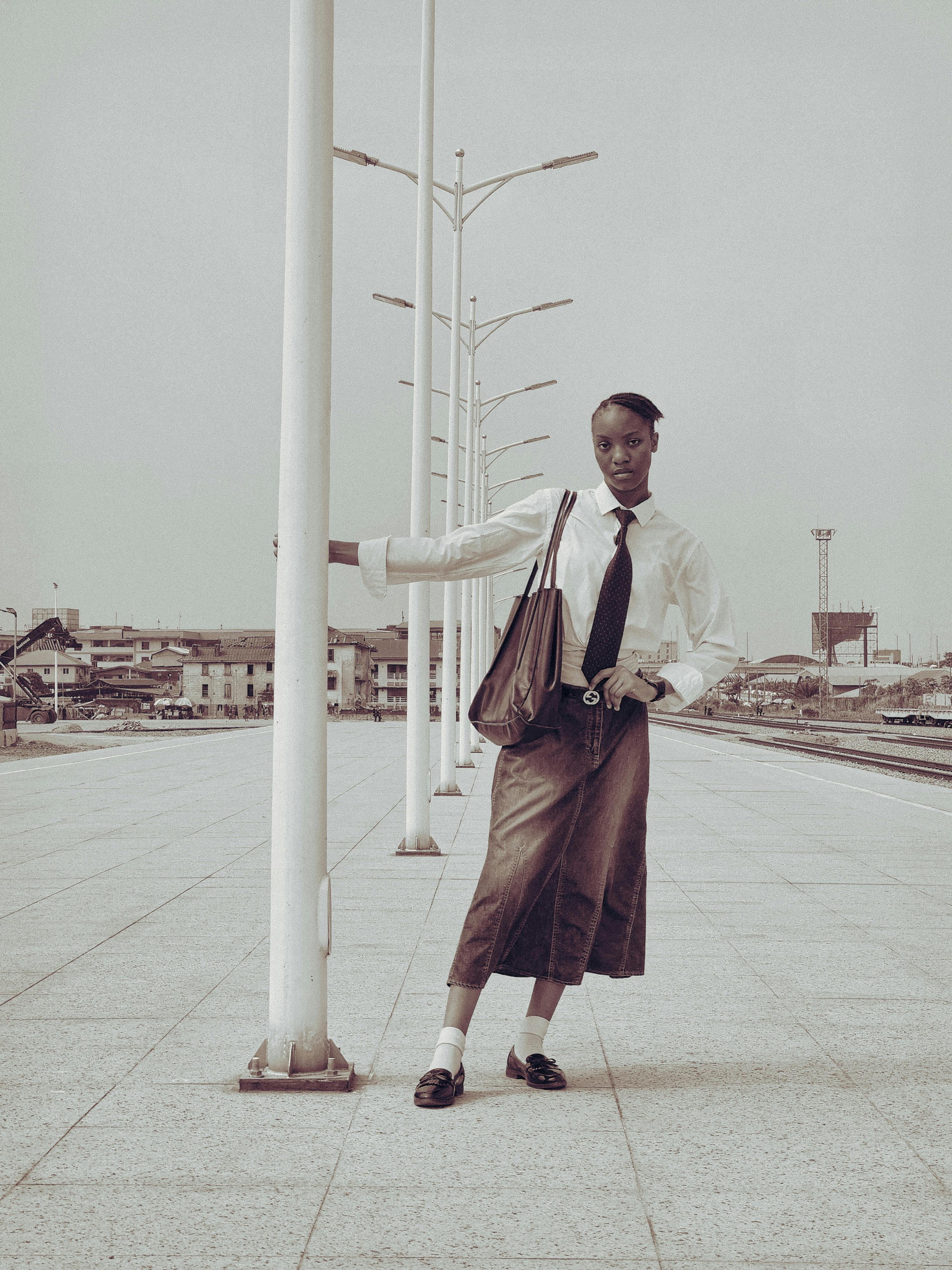 Confident woman posing at a modern train station, exuding style and poise.