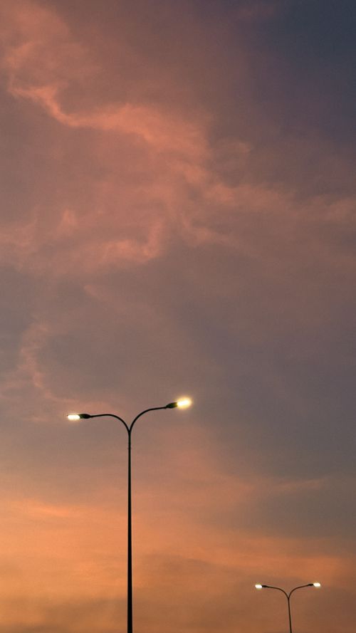 Free Streetlights illuminate as dusk descends over Ho Chi Minh City, casting a serene orange hue over the urban skyline. Stock Photo