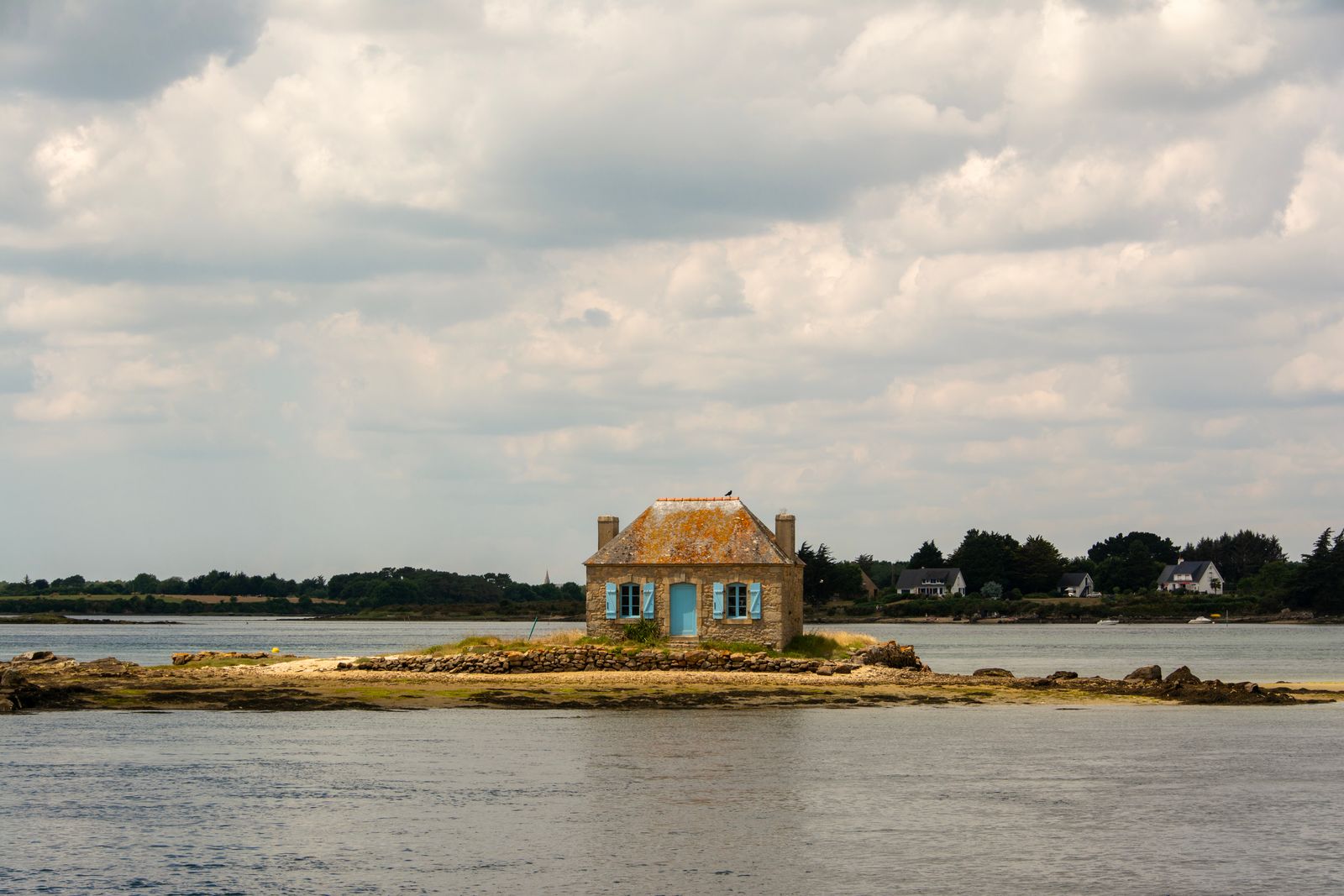 Maison de pêcheur en pierre face à la mer en Bretagne, lumière douce du matin sur la côte
