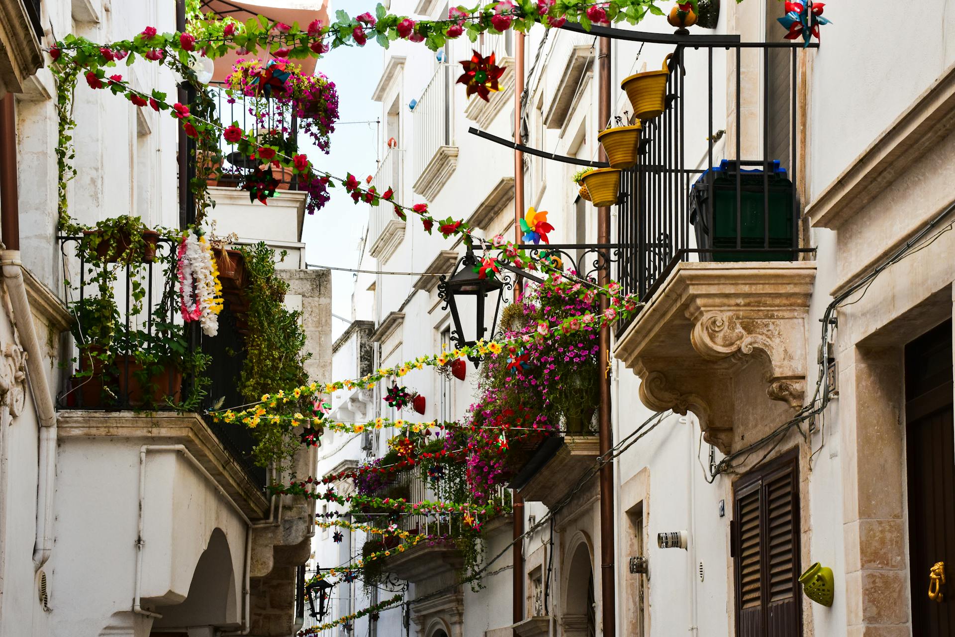 A vibrant Italian street adorned with flowers and decorations, capturing local charm.