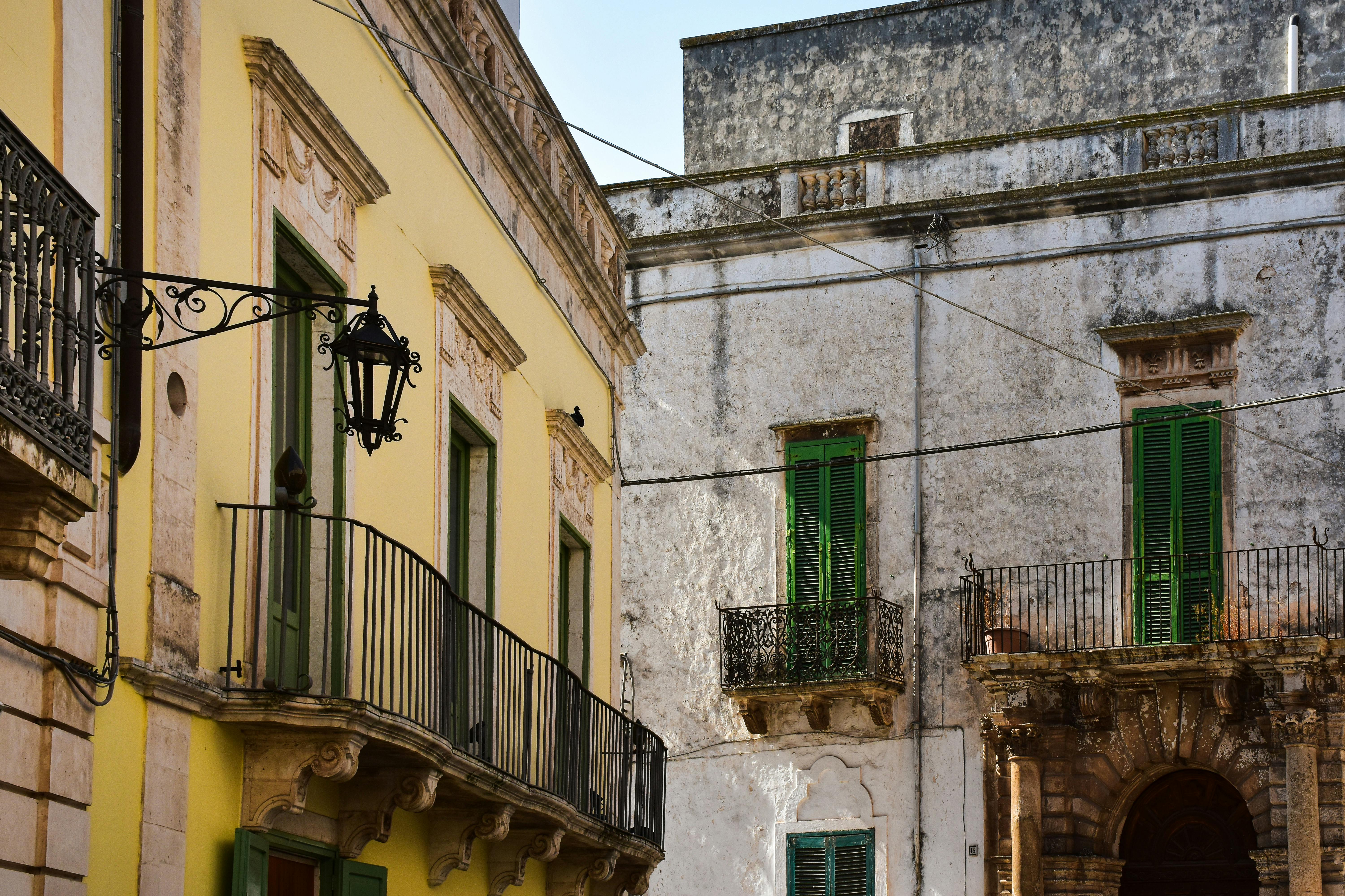 Charming historical buildings with vibrant color and classic balconies in Puglia, Italy.