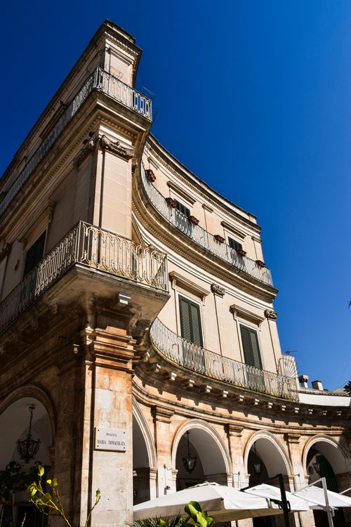 Free Beautiful curved building facade under clear blue sky in Puglia, Italy. Stock Photo