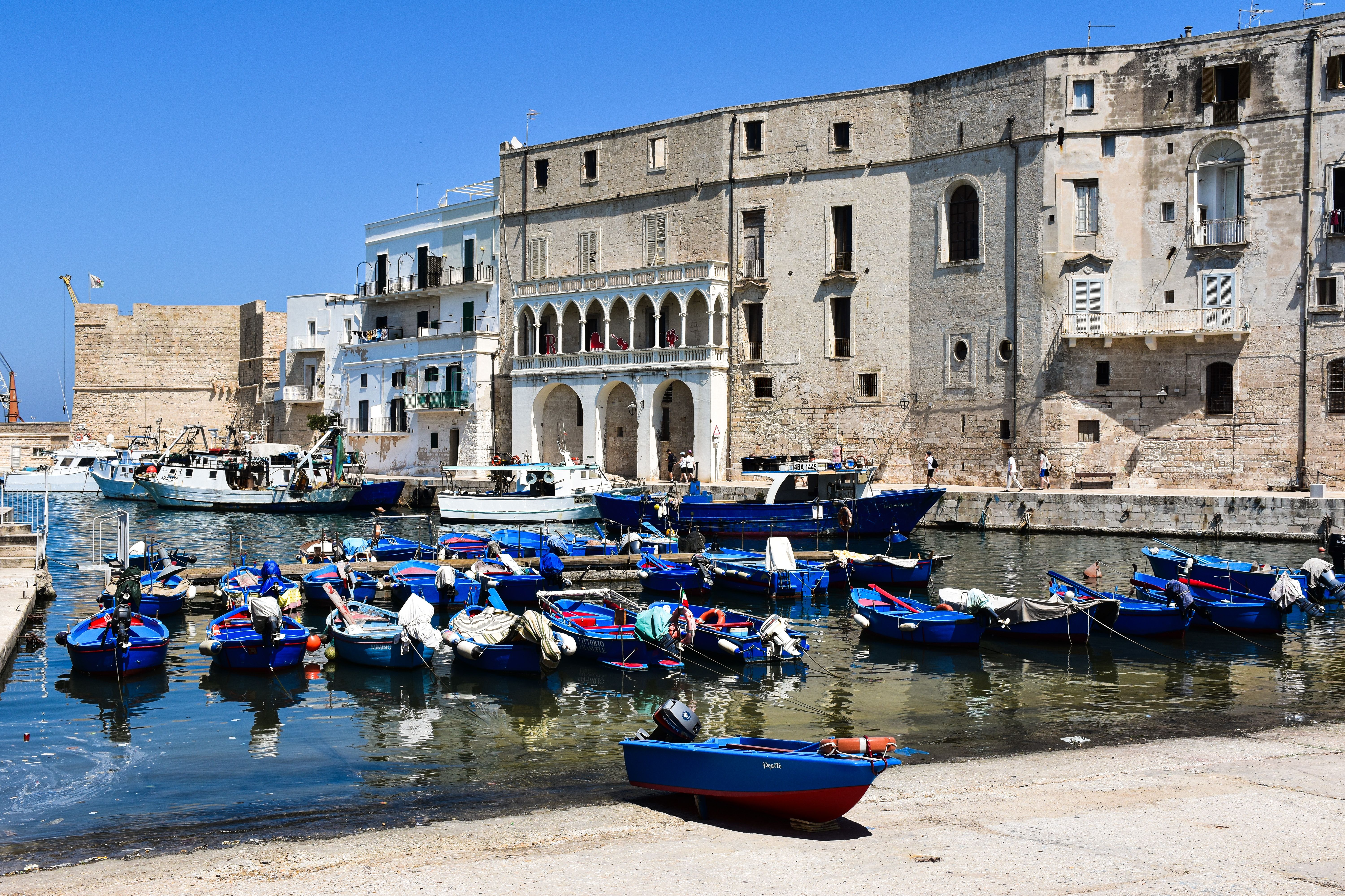 Charming view of Monopoli harbor with colorful boats and historic architecture. Charming view of Monopoli harbor with colorful boats and historic architecture.