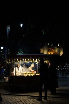 Night scene of street food vendors in Istanbul with illuminated backdrop and bustling ambiance.