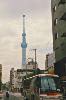 Street view of Tokyo Skytree against city buildings and traffic.
