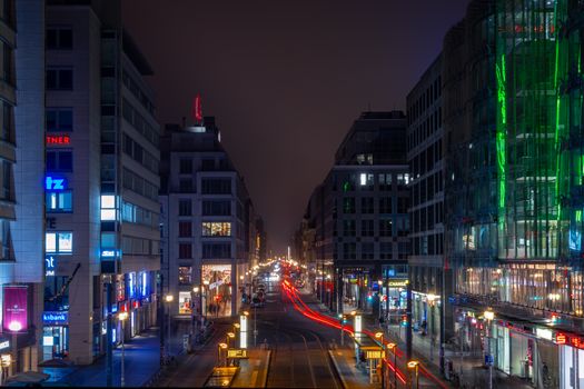 Dynamic night view of a bustling city street with vibrant lights and motion trails.
