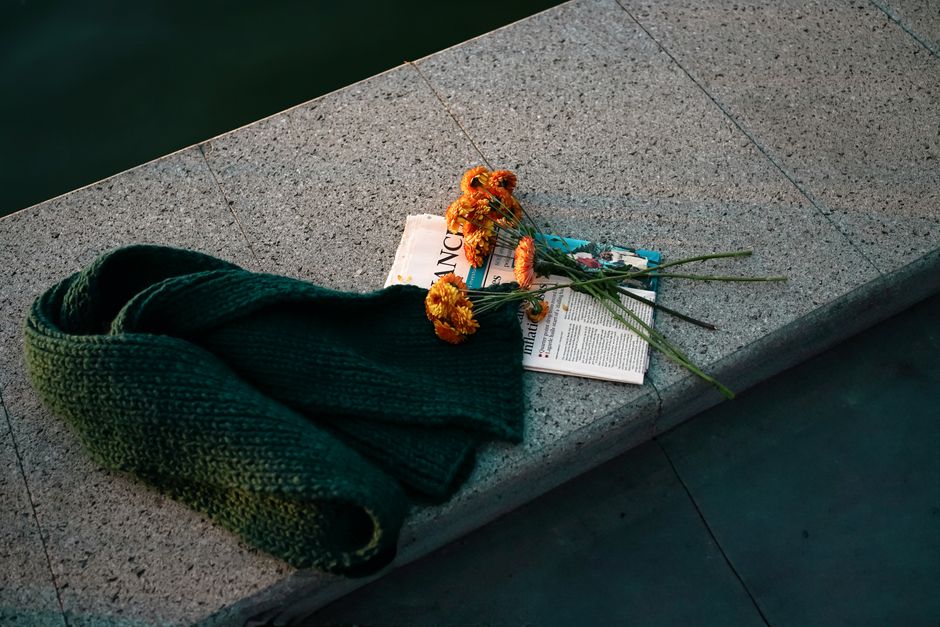 Cozy scene with a green knitted scarf, marigold flowers, and a magazine at dusk.