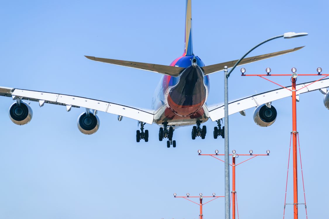 Passenger airplane approaching the runway during daytime against a clear sky