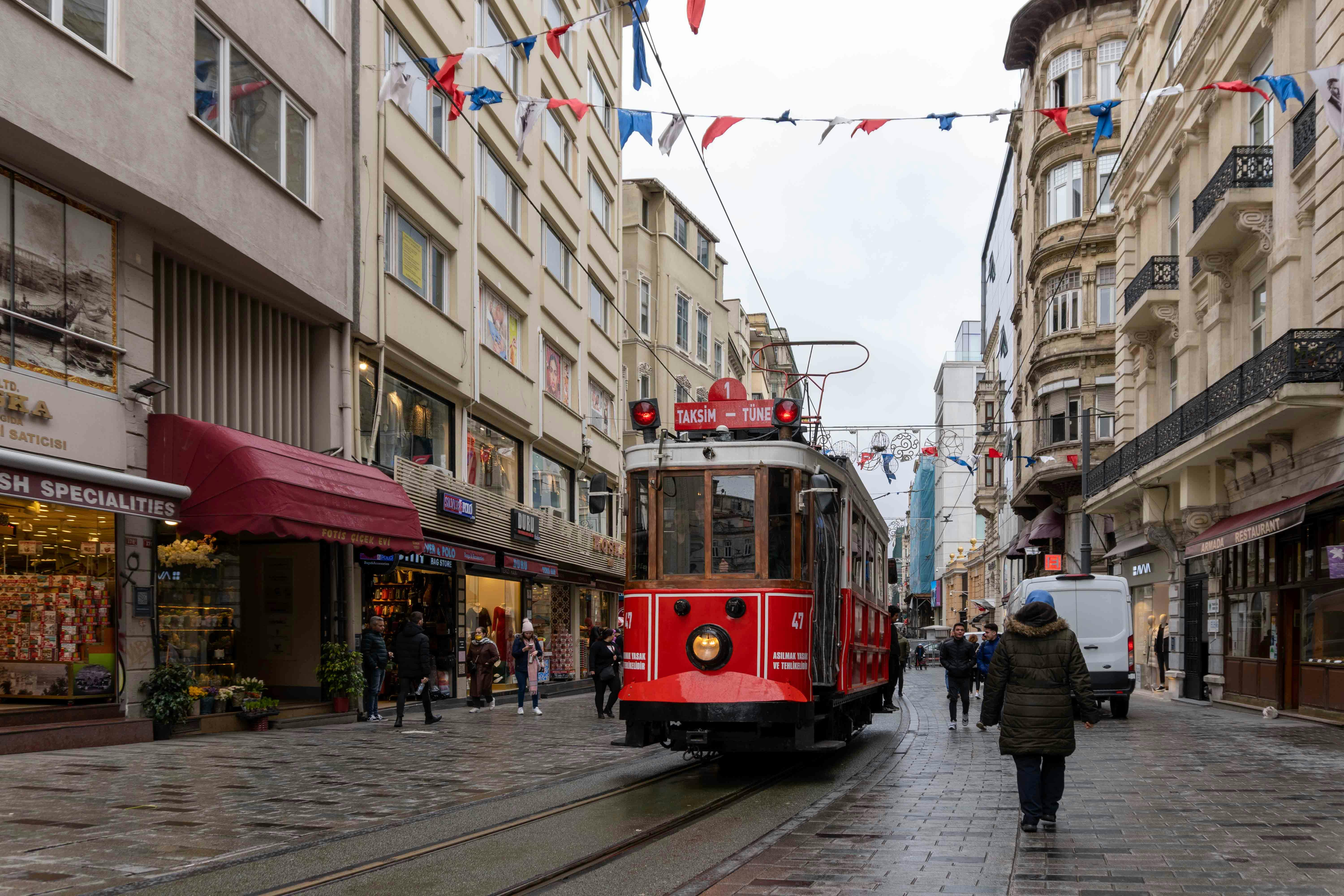 Classic red nostalgic tram on bustling İstiklal Avenue in Istanbul — 1.4km pedestrian street connecting Taksim Square to Galata