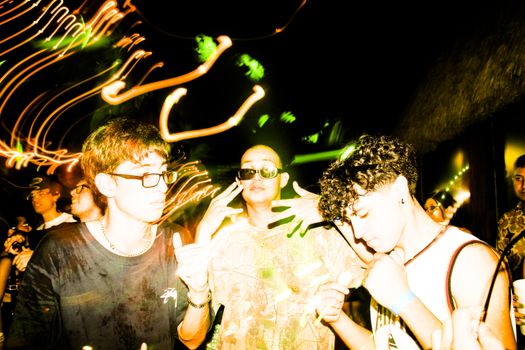 Energetic nightlife scene with friends enjoying a party in Tamaulipas, Mexico, under vibrant lights.